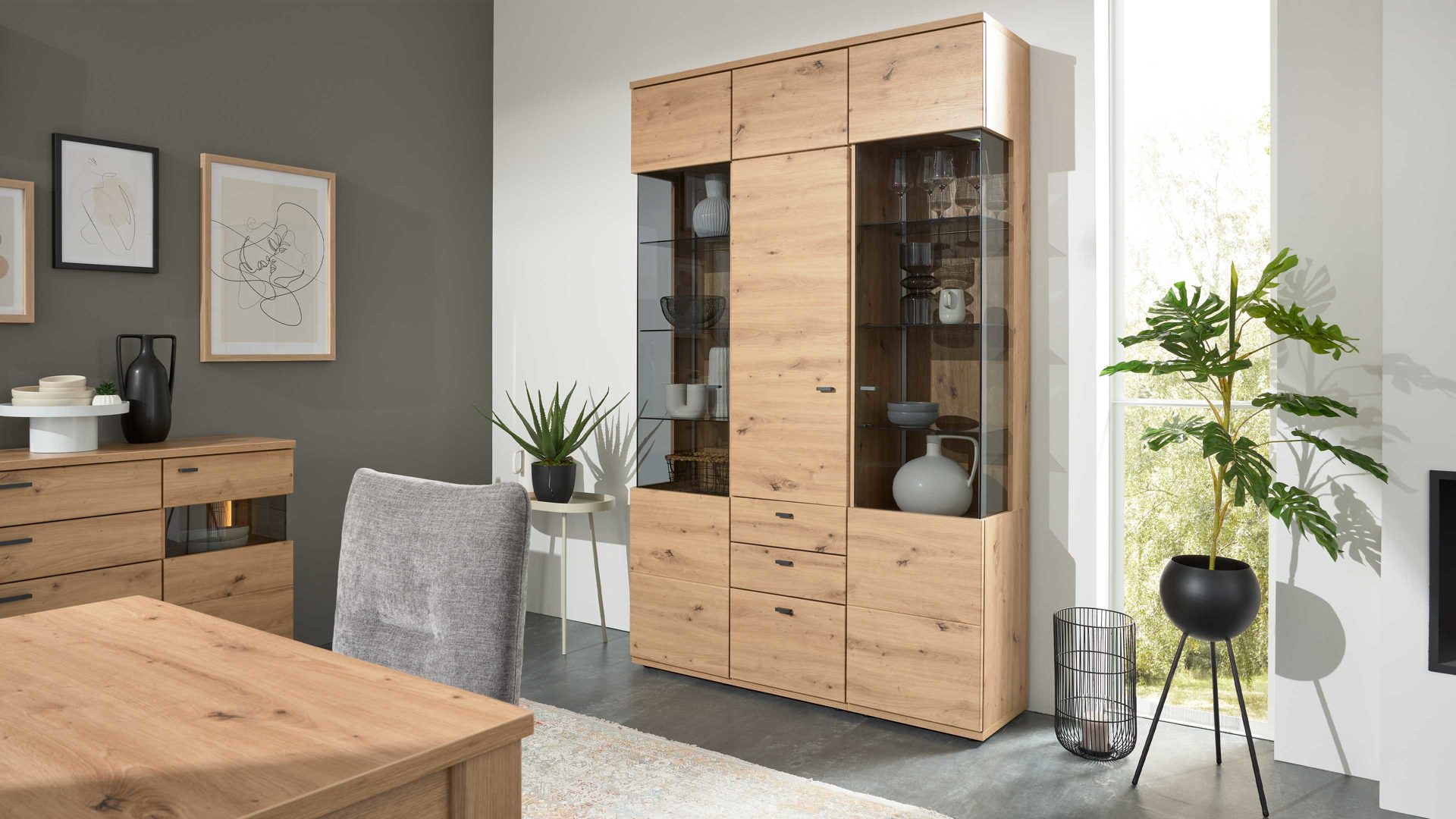 Vitrine Interliving aus Holz in Holzfarben Interliving Wohnzimmer Serie 2110 - Vitrine Alteiche - drei Türen, zwei Schubladen, Breite ca. 135 cm