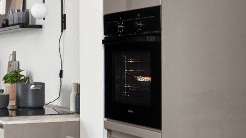 Einbauküche Nobilia® aus Holz in Grau nobilia® Einbauküche Novalux mit Hochglanzfronten und BORA Muldenlüfter Taupegrau & Eiche Como - zweiteilig