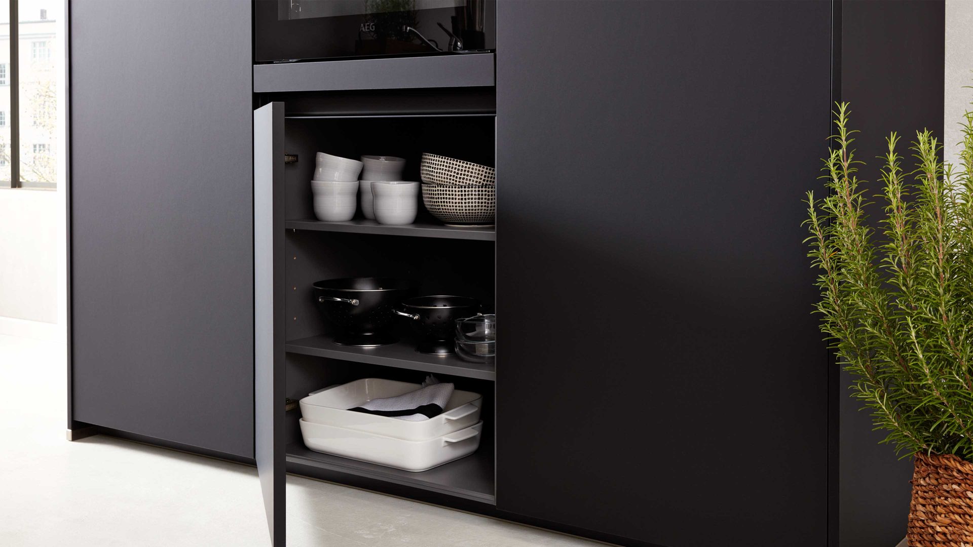 Einbauküche Interliving aus Holz in Schwarz Interliving Küche Serie 3100 mit AEG Einbaugeräten Schwarz & Quarzgrau – zweizeilig