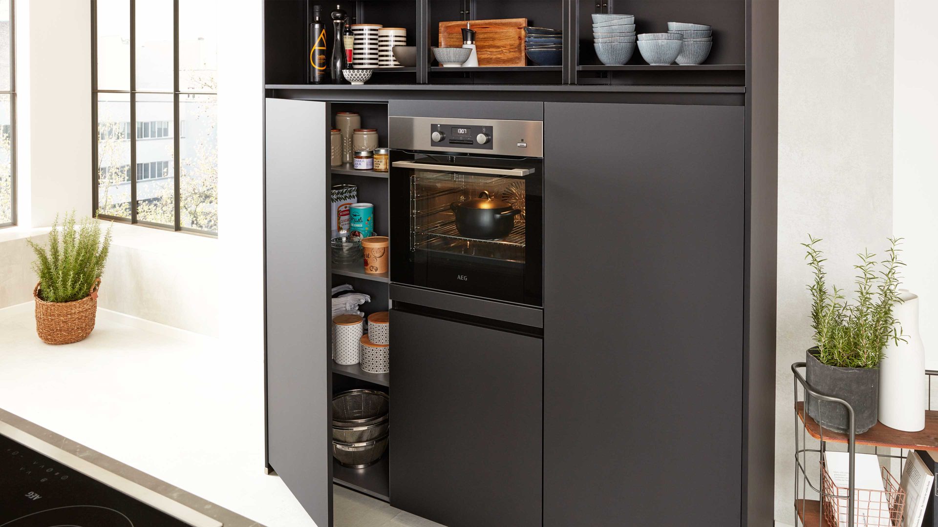 Einbauküche Interliving aus Holz in Schwarz Interliving Küche Serie 3035 mit AEG Einbaugeräten Schwarz & Quarzgrau – zweizeilig