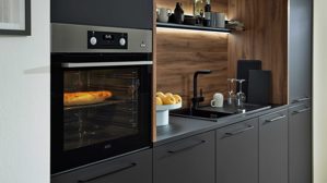 Einbauküche Interliving aus Holz in Schwarz Interliving Küche Serie 3103 mit AEG Einbaugeräten Mattschwarz & Vulkaneiche  - dreizeilig